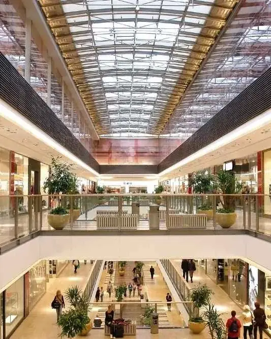 Corredor de um shopping center com lojas nos dois pavimentos