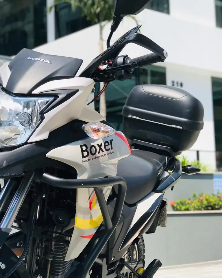 Moto da Boxer em ronda na entrada de um edifício